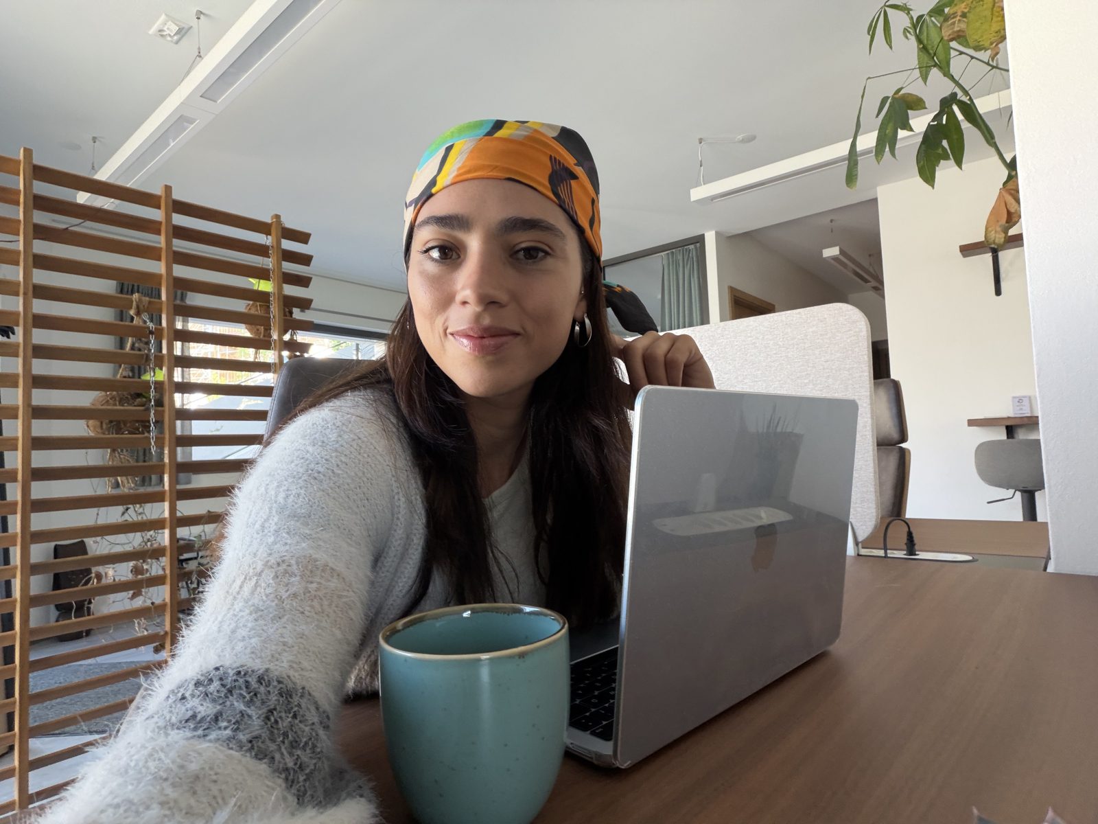 Silvia Gómez sonriendo frente a su ordenador con una taza de café